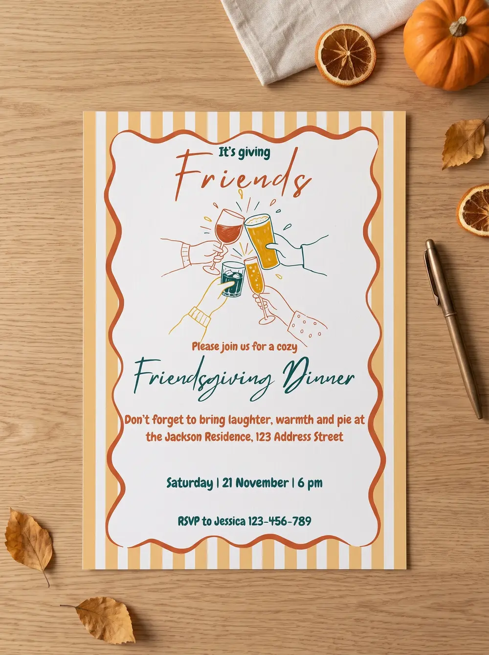 The printed It’s Giving invitation on pale oak, among dried orange slices, a small pumpkin, fallen autumn leaves, a folded linen napkin and a copper pen